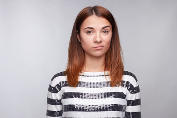 Fototapeta premium What the hell are you talking about, nonsense. Studio shot of frustrated female with red hair, frowning, being displeased and confused with dumb question, isolated over gray studio wall wth copy space