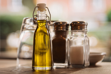 Still life of a bottle of healthy olive oil and salt and pepper slivers