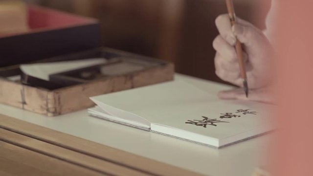 a man hand writing japanese hideograms. 25fps