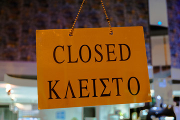 Closed sign board hanging on the glass of a store window