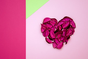 abstract heart made of dried petals on colorful geometric background