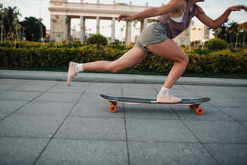 Young sporty woman riding on the longboard in the park © primipil