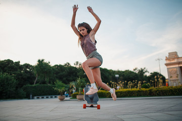Young sporty woman riding on the longboard in the park © primipil