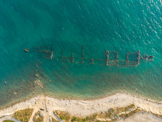 Skeleton of the seagoing ship on the shallow water. Aerial top view