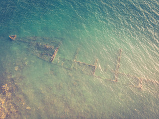 Skeleton of the seagoing ship on the shallow water. Toned image. Aerial top view