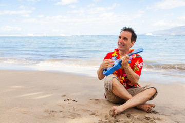 Happy Male Tourist Playing the Ukelele on the Beach with Copy Space