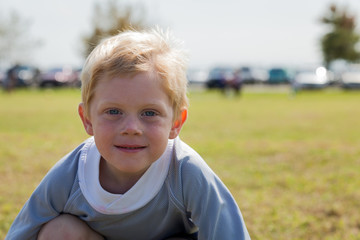 Young Boy Smiling at the Camera Outdoors at a Park