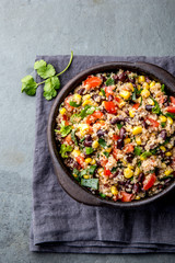 Mexican black bean corn quinoa salad in clay bowl top view, copy space