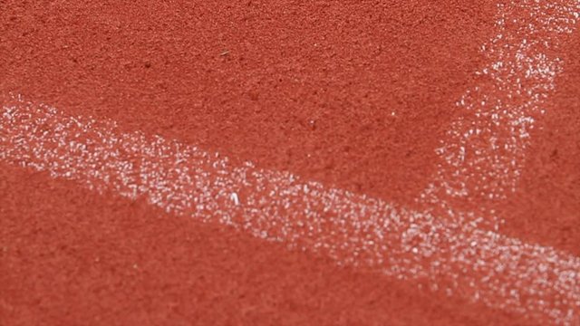 Medium Shot of Tennis Lines and a ball wich bounces on the line. Red Gravel. French Court.