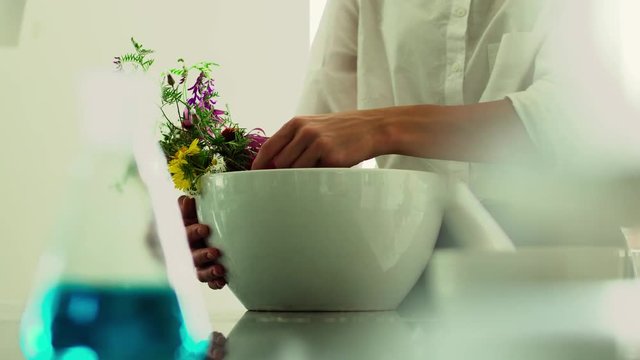 Woman adjusting fresh wildflowers in a deep white plate