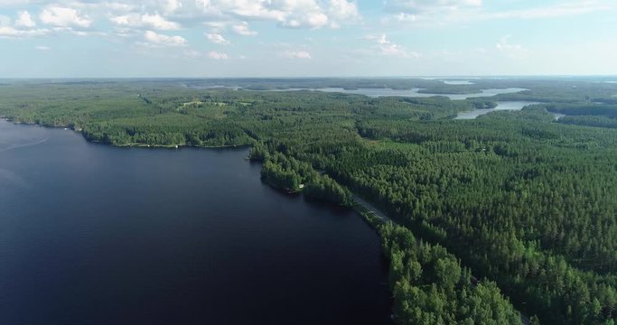 Puumala Finland, road with traffic in the forest by the lake on a summer day seen from the air