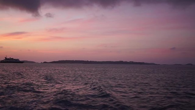 Glorious burning sunset captured from a boat in the middle of the ocean in the Isles of Scilly, UK.
