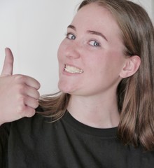 Kaugummi kauendes Mädchen hält Daumen hoch