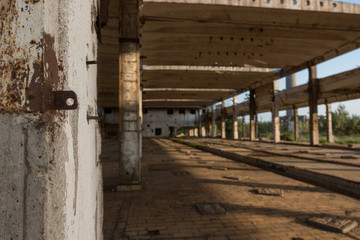 A deserted industrial plant site with old deserted structure on a beautiful sunset.