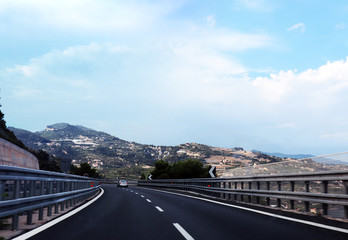 Motorway in Italy, Ventimiglia. Landscape of the Italian riviera with mountains and houses on the hills.