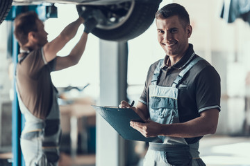 Mechanics Checking Wheel Bearings in Car Workshop