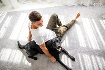 guy with his dog sitting at home playing