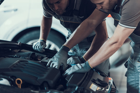 Close-up of Two Mecanics while Fixing Car