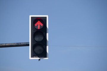 Red traffic light stop car to direct under blue sky.