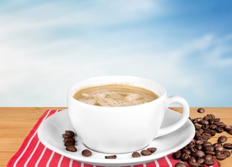 Coffee cup and coffee beans on wooden background
