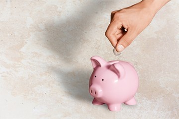 Man putting coin in pig moneybox