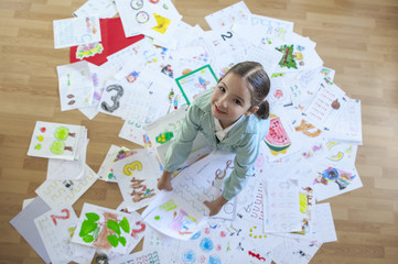Happy five years student over her whole year homework. Overhead shot