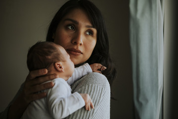 Mother holding her baby indoors © Rawpixel.com