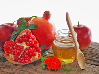 Apples, pomegranates and honey on the wooden board have space for text or symbol with the concept...