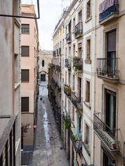 Fototapeta na wymiar Narrow city street with wrought iron balconies in old town near gothic quarter, Barcelona, Spain on an overcast day