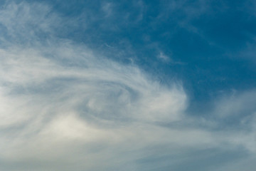 swirling cloudy formation on the blue sky 