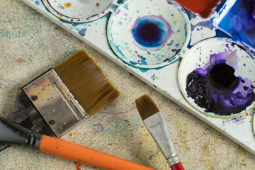 Poster color, Brushes and plastic palette with colorful paints.
