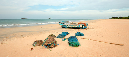 Fototapeta na wymiar Nets, traps, baskets, and ropes next to fishing boat on Nilaveli beach in Trincomalee Sri Lanka