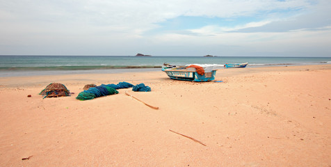 Nets, traps, and ropes next to fishing boat on Nilaveli beach in Trincomalee Sri Lanka
