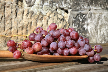 Bunch of grapes hanging on a brick wall an old, country house. An element of outdoor decoration on...