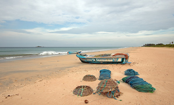 Nets, traps, baskets, and ropes next to fishing boat on Nilaveli beach in Trincomalee Sri Lanka