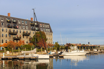grey house and pier with boats and yachts in North End district in Boston