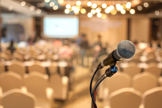 Microphone at the speech podium on blurred conference hall or seminar room background	
