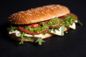 Panini with sesame bun on a dark background