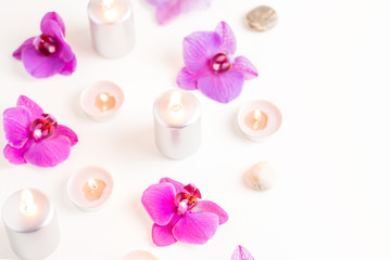 Burning candles and orchid flowers on wooden background. Relaxation spa concept