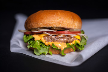 Burger on parchment on a dark background