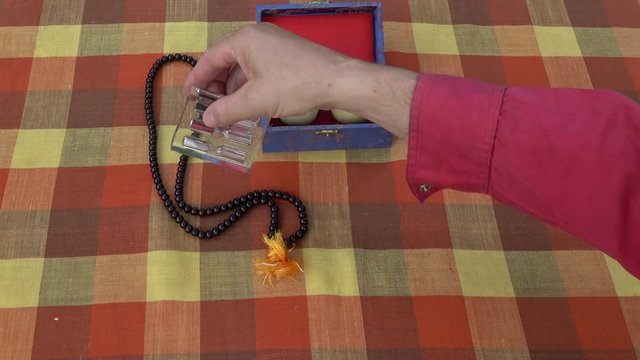 Chinese hand massage balls in hand, hourglass and Buddhists rosary on tablecloth