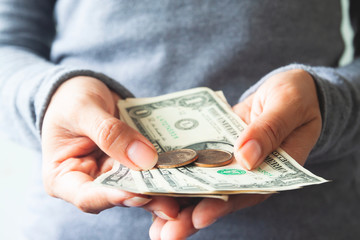 Close up US dollar bills and coins on woman hands. Business and Banking
