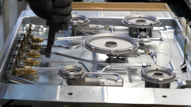 Industrial footage, worker assemble parts and components on a kitchen hob. Filmed in 4K