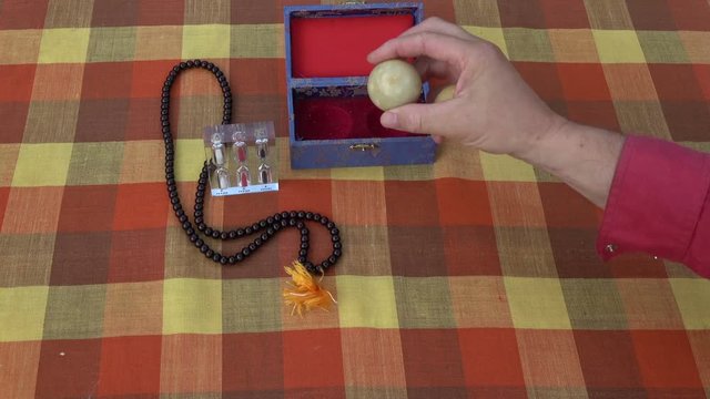 Asian hand massage marble balls in hand, hourglass and Buddhist rosary 