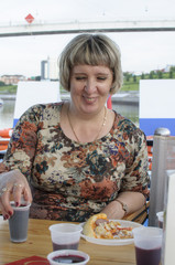 The Russian woman pours drinks juice or wine onboard the motor ship.