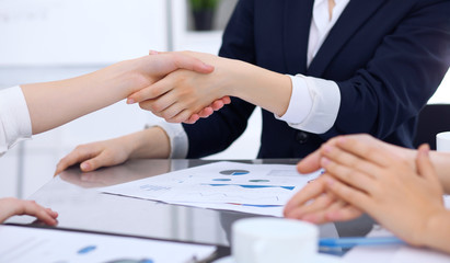 Group of business people shaking hands while finishing up a meeting. Handshaking, agreement or success concept in communication