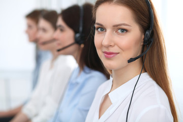Call center. Beautiful cheerful smiling operator consulting clients with headset. Business concept...