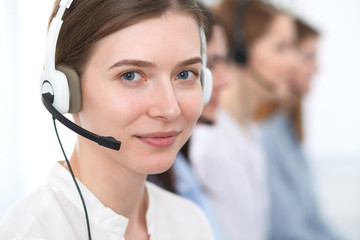Call center. Beautiful cheerful smiling operator consulting clients with headset. Business concept...
