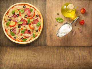pizza and food ingredients at wooden table
