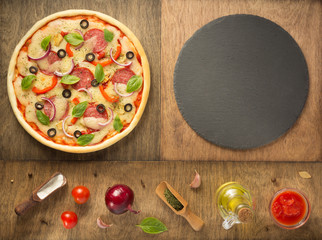 pizza and food ingredients at wooden table